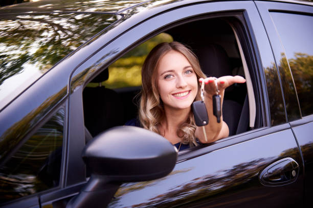 istock Happy young woman with keys in auto. 1166373280