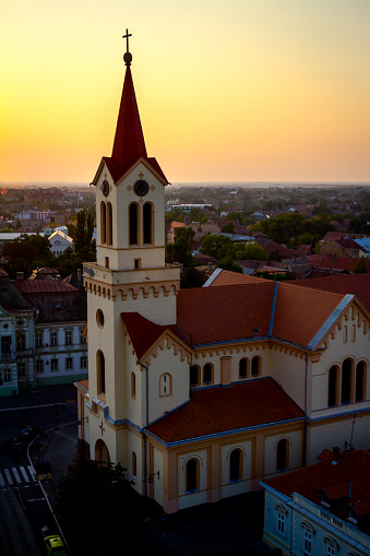 Scenic view on the old city architecture, Catholic Church at spacious town square in sunset.