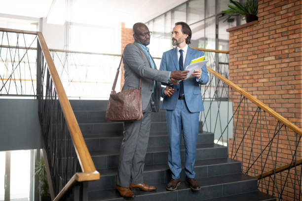 istock Employee showing report to his boss while standing on staircase 1166375301