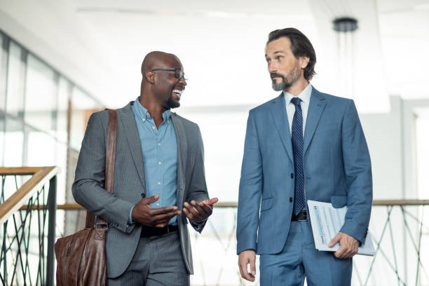 istock Dark-skinned businessman laughing while speaking with colleague 1166375309