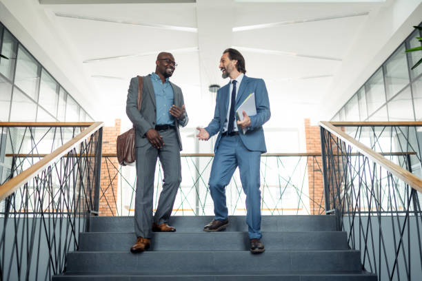 Two businessmen going down the stairs while having lunch break