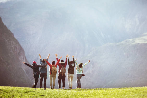 istock Happy hikers against mountain valley with raised arms 1166375919