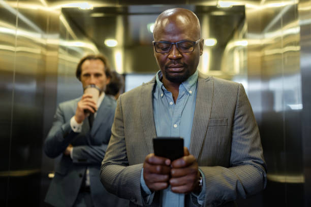istock Dark-skinned young businessman reading message on smartphone 1166375922