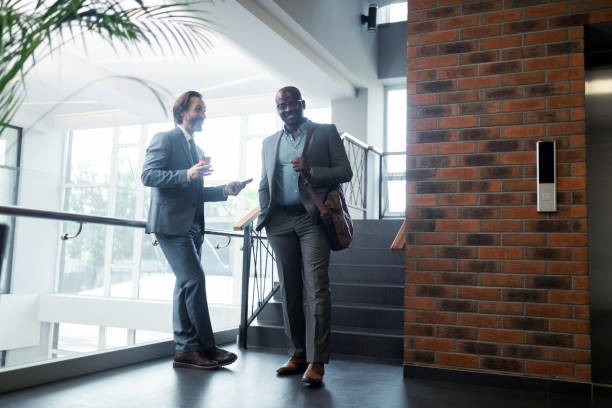 istock Two businessmen smiling while meeting near the elevator 1166375958