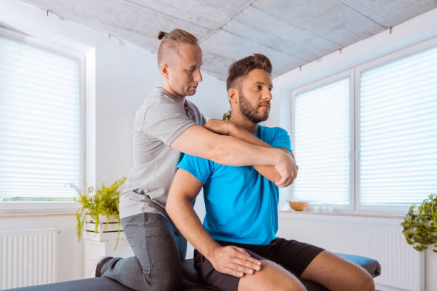 istock Therapist massaging young man at medical center 1166376165