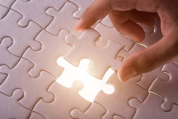 istock Hand holding pieces of jigsaw puzzle and insert into the missing hole 1166376409