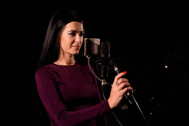 istock Young woman singer in front of microphone. 1166376480