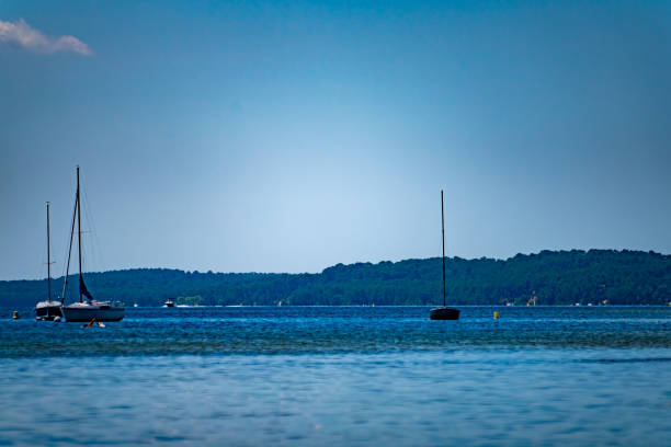 The Lake near Cazaux in Western France below the Arcachon Basin. This shows the lake and  sailboats moored in the late afternoon sun.