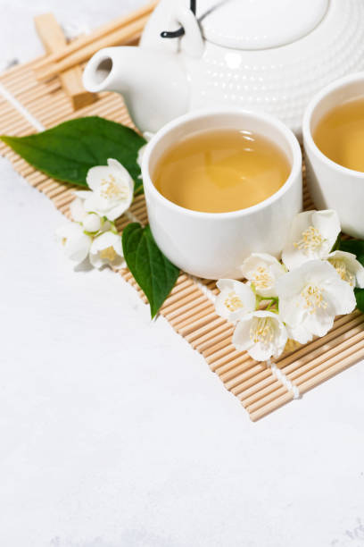 istock japanese tea ceremony. green tea with jasmine. white background, vertical top view 1166376773