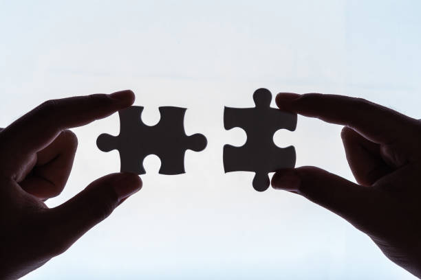 istock Connection concept : Hands holding pieces of jigsaw puzzle on white 1166376816