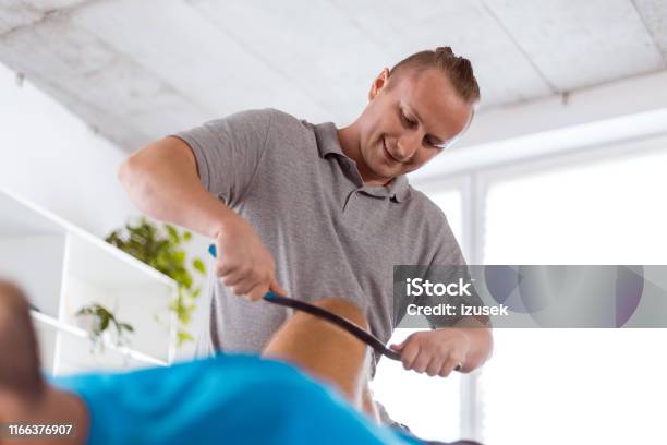 Therapist Giving Knee Massage Using A Tool Stock Photo - Download Image Now - Knee, Physical Therapy, Adult