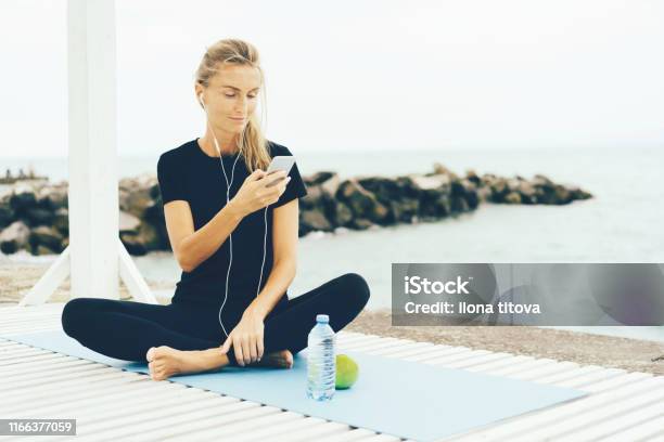 Woman After Workout With A Phone In Her Hands Stock Photo - Download Image Now - Mail, Exercising, Gym