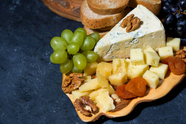 istock cheese platter on a wooden board, bread and fruit, top view 1166377107