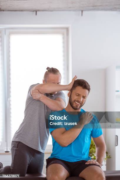 Therapist Doing Some Chiropractic Adjustment To Man Neck Stock Photo - Download Image Now