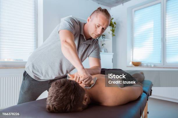 Professional Therapist Giving Back Massage With A Tool Stock Photo - Download Image Now
