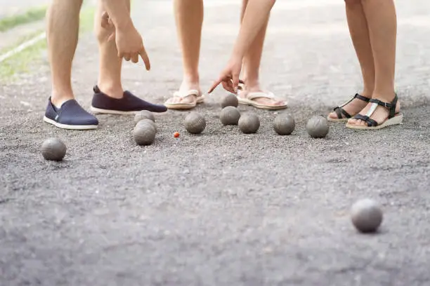 Players measure distance in petanque boule french game find out who is winner