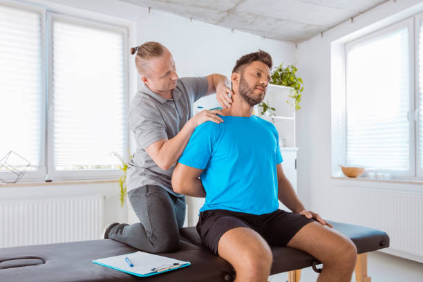 istock Physiotherapist giving neck massage to a young man 1166378540