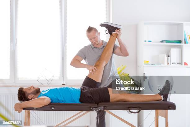 Physiotherapist Assisting A Young Patient In Recovery Stock Photo - Download Image Now