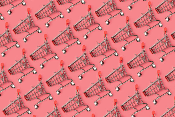 istock Small empty shopping carts perform a pattern on a pastel colored paper background. Modern trendy design for any purposes. 1166380012