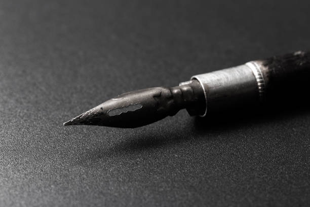 istock Old fountain pen on a black textured background 1166382324