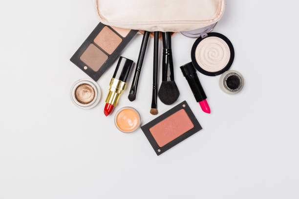 istock Makeup products with cosmetic bag and macaroons on light background 1166383034