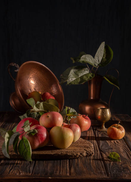 Classical still life with organic natural apples and vintage cooper decoration on old rustic wooden background.