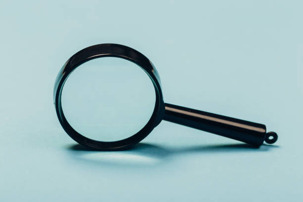 istock Small magnifying glass on pastel blue background, search symbol 1166383491