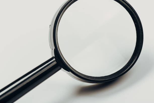 istock Small magnifying glass on light background, search symbol 1166383561