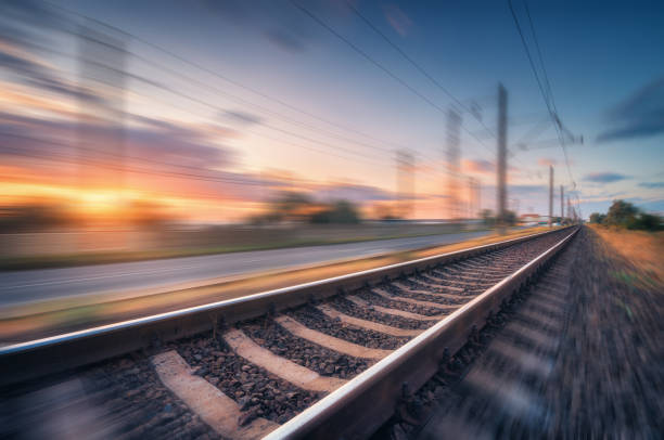 istock Railroad and beautiful blue sky with clouds at sunset with motion blur effect in summer. Industrial landscape with railway station and blurred background.  Railway platform in speed motion. Concept 1166383689