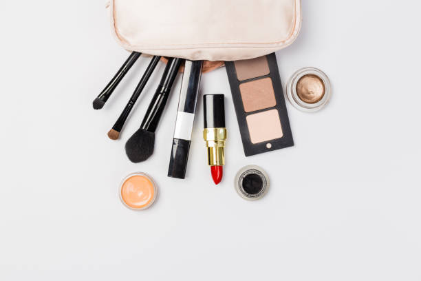 istock Makeup products with cosmetic bag and macaroons on light background 1166385384