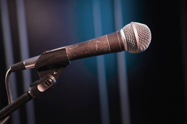 istock side view of the microphone on stage on a blue background, toned picture 1166385493