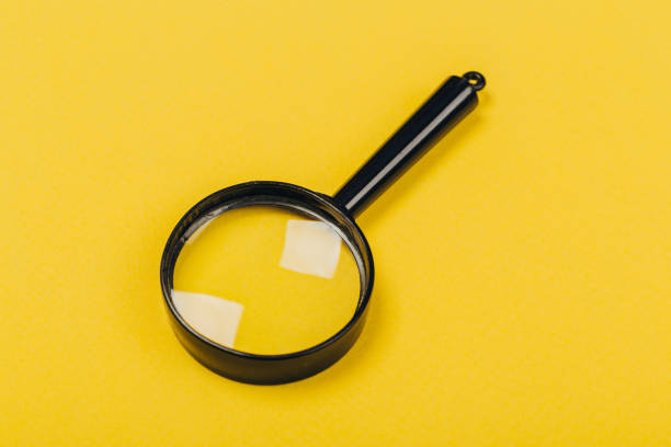 istock Small magnifying glass on yellow background, search symbol 1166385608