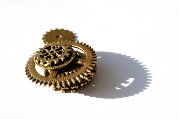 istock a small tower of gears casts a shadow on white paper 1166386026