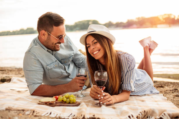 istock Beautiful young couple enjoying picnic on a beach 1166387028