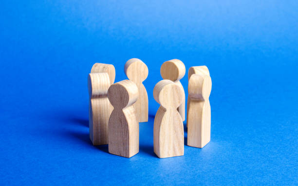 istock People figurines stand in a circle. discussion, cooperation. Employees briefing. Organization of work and processes. Meeting at work, negotiating a plan of action. teamwork. Society and community. 1166387549