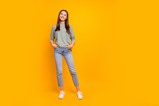 Full length body size photo of nice cute encouraged girlfriend with, her hands in pockets while isolated with yellow background