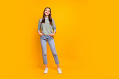 Full length body size photo of nice cute encouraged girlfriend with her hands in pockets while isolated with yellow background