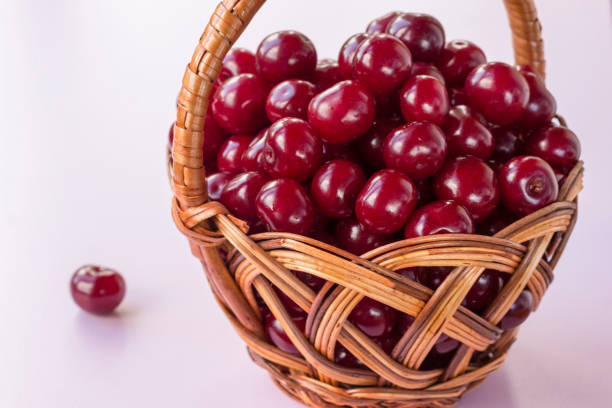 istock Cherry berries in a wicker basket. White background 1166390881