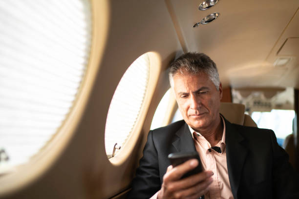 Businessman using smartphone in a private jet