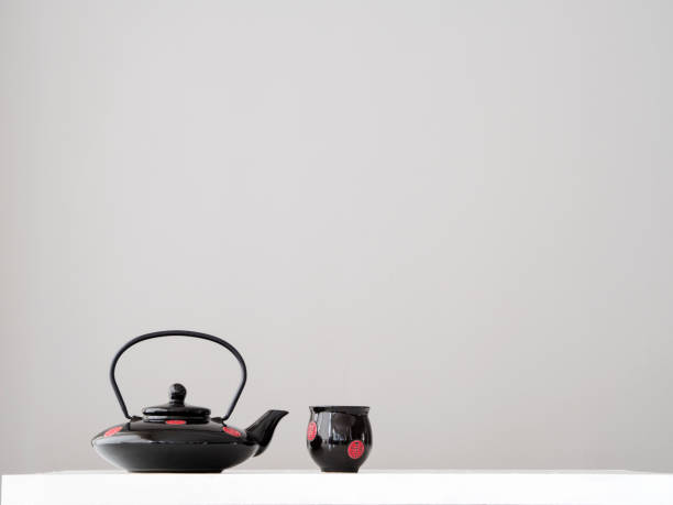 Black teapot and cup on grey  background