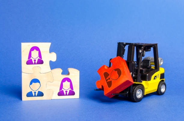A forklift truck carries a red puzzle to the unfinished assembly of business team. Search, recruitment staff, hiring leader. Creating an efficient and productive business unit. Leadership and teamwork una carretilla elevadora lleva un rompecabezas rojo al ensamblaje inacabado del equipo de negocios. búsqueda, personal de reclutamiento, líder de contratación. crear una unidad de negocio eficiente y productiva. liderazgo y trabajo en equipo