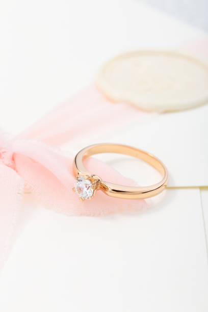 istock Wedding diamond ring on pastel background with pink ribbon 1166392749
