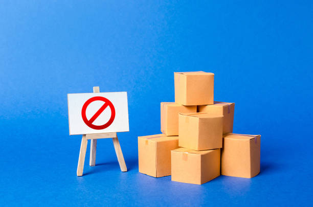 istock A stack pile cardboard boxes and a sign stand with red symbol NO. Restriction on the importation of goods, proprietary for business. Embargo, trade wars. Inability to sell products, ban on the import. 1166392941