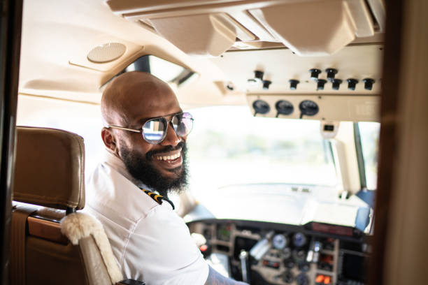 ritratto di pilota di aeroplano che guarda oltre la spalla in un jet privato - captain foto e immagini stock