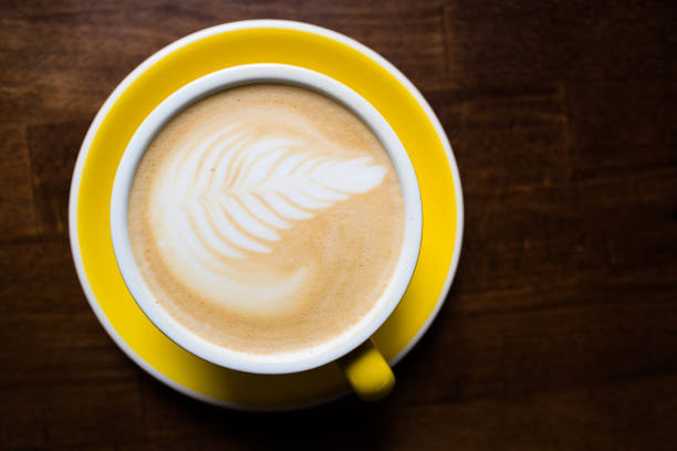 istock Yellow cup of aromatic coffee on a wooden table. 1166393929