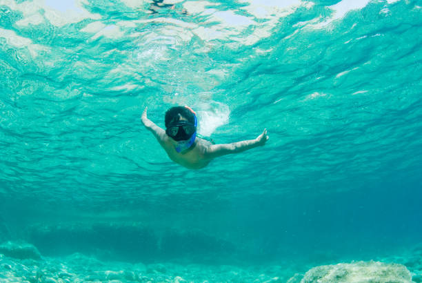 istock Child snorkeling in clear sea waters. 1166394402