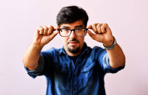 Close up of a man holding eyeglasses before trying them on, Man choosing wearing glasses