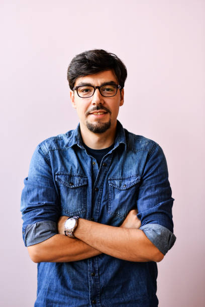 istock Young man in blue shirt over pink background 1166397471
