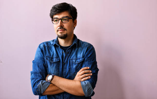 istock Young man in blue shirt over pink background 1166397683