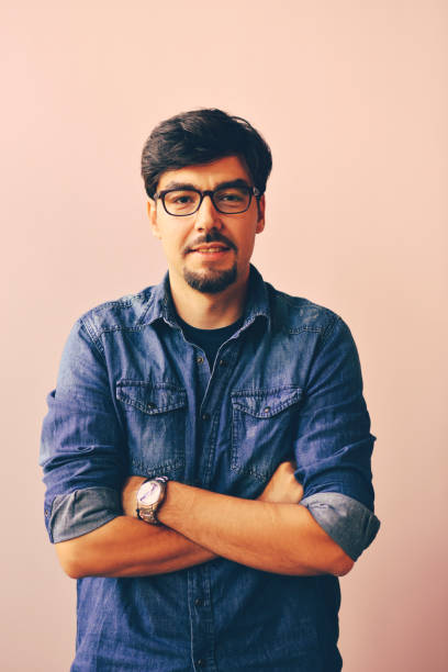 istock Young man in blue shirt over pink background 1166397723